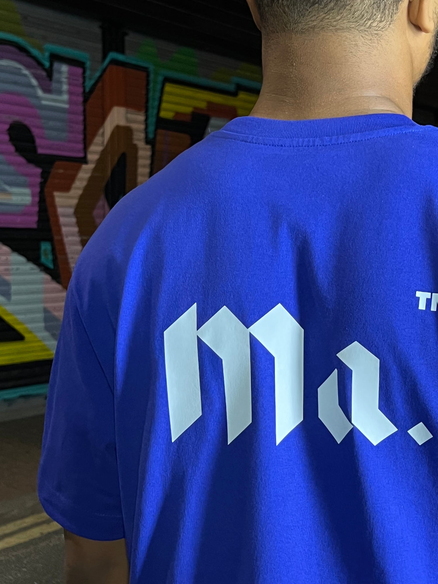 Back of the More amoure cobalt blue oversized t-shirt with the classic Ma. logo